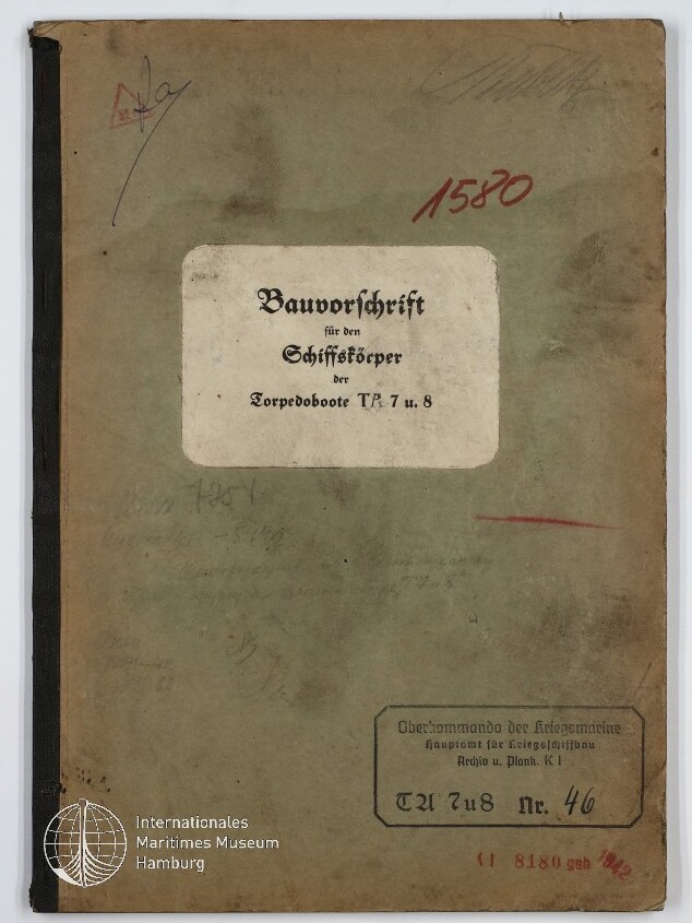 Verschmutzter grüner Einband eines alten technischen Hefts mit mittig aufgeklebtem weißen Etikett mit dem Titel Bauvorschrift für den Schiffskörper der Torpedoboote T5, 7 u. 8, roten Stempeln und Museumswasserzeichen unten links