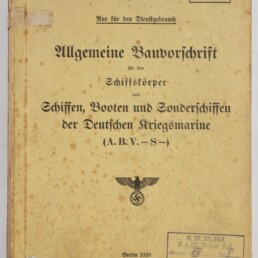 Vergilbtes, braun geflecktes Dienstheft von 1938 mit Frakturschrift-Titel »Allgemeine Bauvorschrift für den Schiffskörper … der Deutschen Kriegsmarine«, handschriftlichen Notizen, mehreren Stempeln sowie einem Reichsadler mit Hakenkreuz unterhalb der Titelzeile.