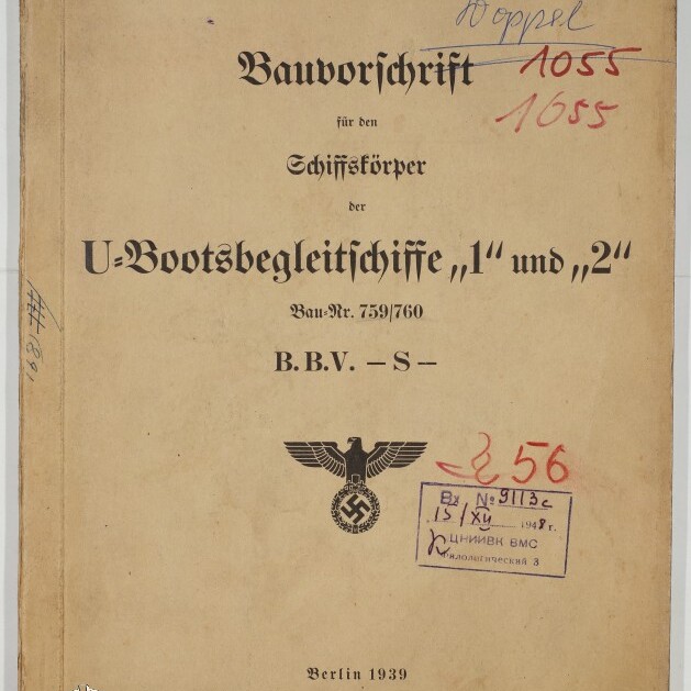 Vergilbte Umschlagseite einer 1939 in Berlin erschienenen Dienstvorschrift mit dem Titel Bauvorschrift für den Schiffskörper der U-Bootsbegleitschiffe 1 und 2, versehen mit einem Reichsadler über einem Hakenkreuz, mehreren handschriftlichen Nummern, Stempeln und einem Museumswasserzeichen.