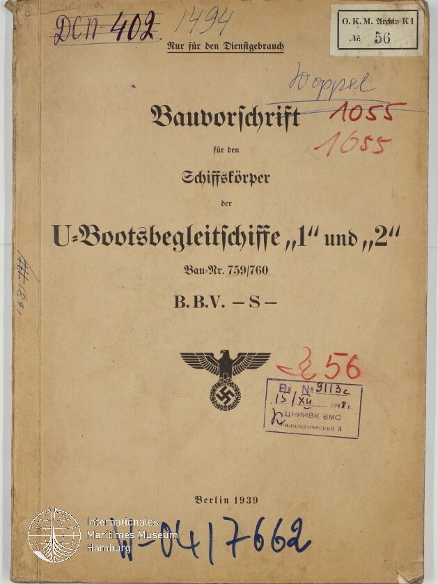 Vergilbte Umschlagseite einer 1939 in Berlin erschienenen Dienstvorschrift mit dem Titel Bauvorschrift für den Schiffskörper der U-Bootsbegleitschiffe 1 und 2, versehen mit einem Reichsadler über einem Hakenkreuz, mehreren handschriftlichen Nummern, Stempeln und einem Museumswasserzeichen.