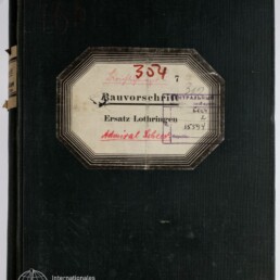 Schwarzer Leineneinband eines dicken Buchs mit aufgeklebtem achteckigen Etikett, darauf handschriftliche Einträge und Stempel, die Aufschrift ‚Bauvorschrift Ersatz Lothringen Admiral Scheer‘ sowie rot geschriebene Nummer 304; unten links das Logo des Internationalen Maritimen Museums Hamburg.