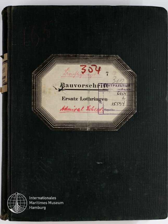 Schwarzer Leineneinband eines dicken Buchs mit aufgeklebtem achteckigen Etikett, darauf handschriftliche Einträge und Stempel, die Aufschrift ‚Bauvorschrift Ersatz Lothringen Admiral Scheer‘ sowie rot geschriebene Nummer 304; unten links das Logo des Internationalen Maritimen Museums Hamburg.
