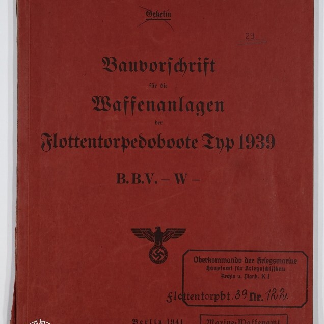 Rotes Deckblatt eines 1941 in Berlin erschienenen deutschen Marinehandbuchs mit schwarzer Frakturschrift »Bauvorschrift für die Waffenanlagen der Flottentorpedoboote Typ 1939«, Stempeln und handschriftlichen Markierungen sowie einem Hoheitszeichen Adler mit Hakenkreuz und einem Museumssignet unten links.