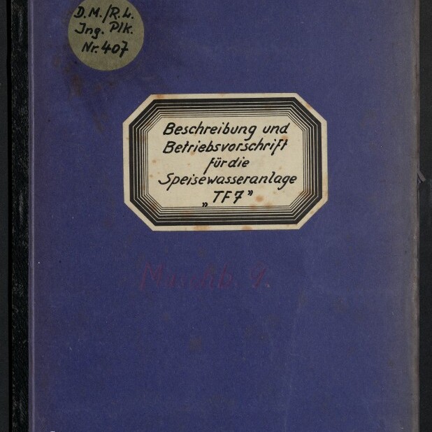 Vorderseite eines violettblauen Heftes mit schwarzem Rücken, mittig ein achteckiges Etikett mit handschriftlicher Aufschrift „Beschreibung und Betriebsvorschrift für die Speisewasseranlage ‚TF7’“, oben links ein runder handbeschrifteter Aufkleber und unten links das Logo des Internationalen Maritimen Museums Hamburg.