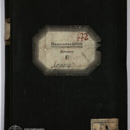 Schwarzer Leineneinband eines alten Buchs mit abgegriffenem Buchrücken, mittig aufgeklebt ein achteckiges, gealtertes Etikett mit der Aufschrift „Bauvorschrift Kreuzer E Leipzig“ und roter Ziffer ‚172‘, unten rechts ein kleines weiteres Etikett und links unten das Logo des Internationalen Maritimen Museums Hamburg.