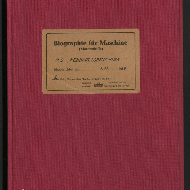 Weinrotes Leinenbuch mit mittig aufgeklebtem beigen Etikett 'Biographie für Maschine (Motorschiffe)', handschriftlichem Eintrag 'M.S. REINHART LORENZ RUSS' und Datum '1.11.1969', unten links Logo des Internationalen Maritimen Museums Hamburg.
