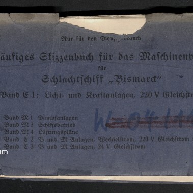Abgewetztes blaues Heft mit deutschem Titel „Vorläufiges Skizzenbuch für das Maschinenpersonal für Schlachtschiff ‚Bismarck‘ — Band C1: Licht- und Kraftanlagen, 220 V Gleichstrom“, handschriftlichen Markierungen, kleinem weißen Aufkleber oben links, roter Zahl oben rechts und dem Logo des Internationalen Maritimen Museums Hamburg unten links.