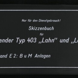 Schwarzer Buch- bzw. Mappeumschlag mit weißem Rahmen, gedrucketem deutschen Titel „Nur für den Dienstgebrauch! Skizzenbuch für Tender Typ 403 ‚Lahn‘ und ‚Lech‘ Band E 2: BuM Anlagen“ und dem Logo des Internationalen Maritimen Museums Hamburg unten links