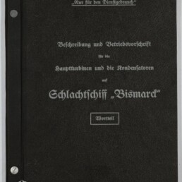 Schwarzer Einband eines technischen Diensthandbuchs mit weißer Frakturschrift: ‚Nur für den Dienstgebrauch‘ und dem Titel ‚Beschreibung und Betriebsvorschrift für die Hauptturbinen und die Kondensatoren auf Schlachtschiff „Bismarck“‘; links Metallverschlüsse am Rücken und unten links Logo sowie Schriftzug des Internationalen Maritimen Museums Hamburg.