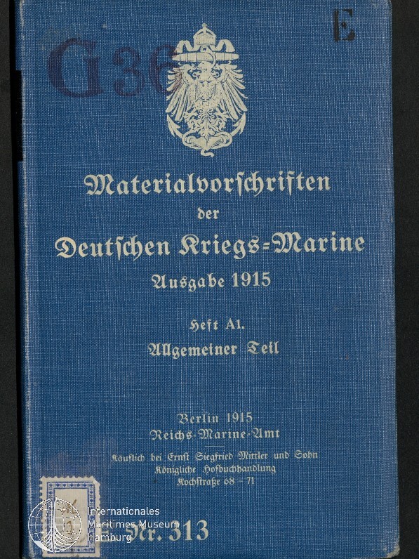 Blaues Buchcover mit weißem Reichsadler oben und in Frakturschrift der Titel ‚Materialvorschriften der Deutschen Kriegs‑Marine, Ausgabe 1915, Heft A1 Allgemeiner Teil‘ sowie Verlagsangaben und Museumsstempel unten links.