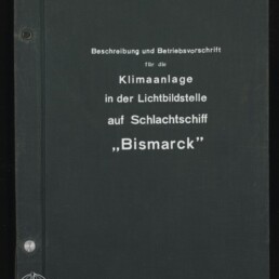 Schwarzer Ordnerdeckel mit weißer deutscher Beschriftung ‚Beschreibung und Betriebsvorschrift für die Klimaanlage in der Lichtbildstelle auf Schlachtschiff „Bismarck“‘, links unten Logo und Schriftzug des Internationalen Maritimen Museums Hamburg sowie sichtbare Metallklammern am Buchrücken.