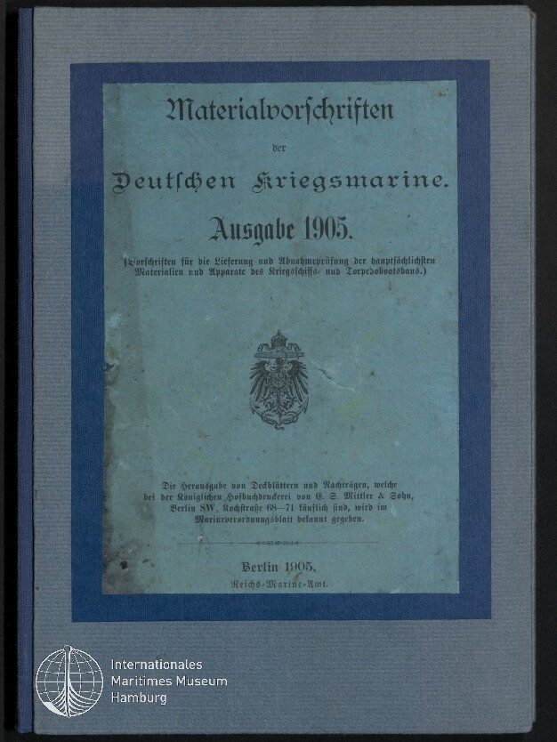 Gebundener Umschlag in blassblau mit dunklem Rand, aufgedruckter Frakturschrift: 'Materialvorschriften der Deutschen Kriegsmarine Ausgabe 1905', kaiserliches Adlerwappen mittig und Logo des Internationalen Maritimen Museums Hamburg unten links.