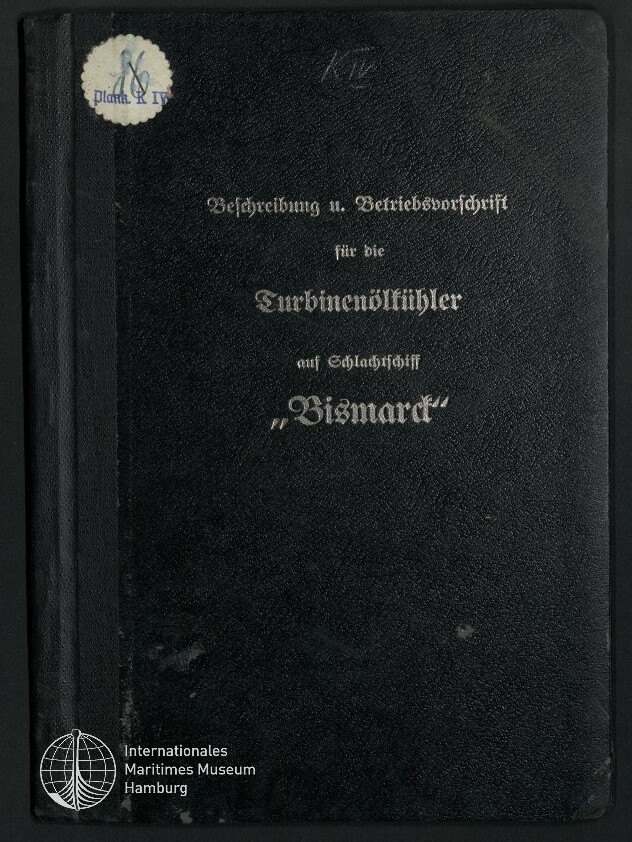 Schwarzer Leineneinband eines Handbuchs mit silberner Frakturschrift, auf dem als Titel die Betriebsanweisung für Turbinenöl mit dem Schiffsnamen „Bismarck“ steht; oben links ein runder Aufkleber, unten links das Logo des Internationalen Maritimen Museums Hamburg.