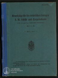 Buchumschlag eines historischen Hefts mit blaugrünem Einband und blauem Leinenrücken, schwarzer Frakturschrift mit dem Titel „Grundzüge für die elektrischen Anlagen S. M. Schiffe und Torpedoboote“, Datierung „März 1908“, kaiserliches Adlerwappen in der Mitte, kleiner Stempel „Vertraulich“ oben rechts und Logo des Internationalen Maritimen Museums Hamburg unten links.