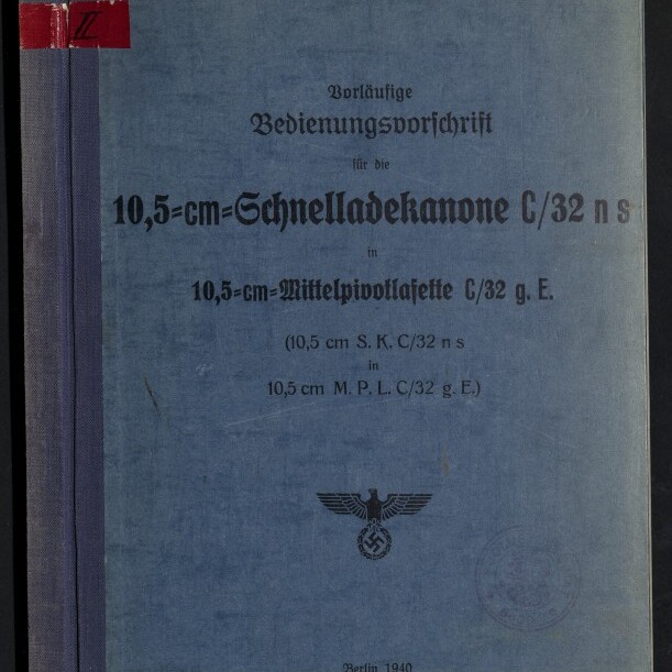 Blaue, leicht abgenutzte Titelseite einer deutschen Dienstvorschrift von 1940 mit dem großgedruckten Titel 10,5‑cm‑Schnelladekanone C/32, darunter ein Reichsadler mit Hakenkreuz, ein runder Stempel und das Wasserzeichen des Internationalen Maritimen Museums Hamburg.