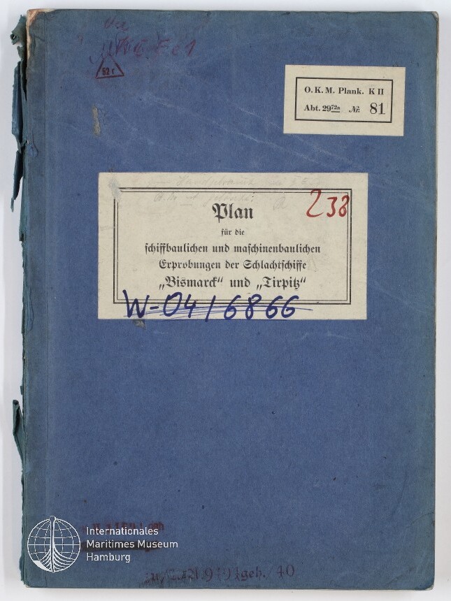 Blaues, leicht abgenutztes Heft mit mehreren Papieretiketten: zentrales weißes Etikett mit dem gedruckten Titel Plan für die schiffbaulichen und maschinenbaulichen Erprobungen der Schlachtschiffe Bismarck und Tirpitz, handschriftlichen roten und blauen Vermerken sowie kleinem Etikett oben rechts und Museumslogo unten links.