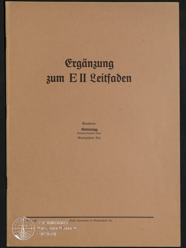 Beiger Buchumschlag auf dunklem Hintergrund mit schwarzem Frakturschrift-Titel Ergänzung zum E II Leitfaden, kleinem Bearbeitertext in der Mitte und Museumswasserzeichen unten links.