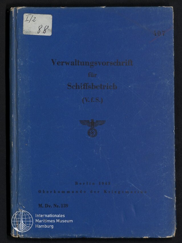 Blauer, leicht abgenutzter Buchdeckel mit dem Titel „Verwaltungsvorschrift für Schiffsbetreib (V.f.S.)“, mittig ein Hoheitsadler mit Hakenkreuz, handschriftlicher Aufkleber oben links und kleines Museumslogo unten links.