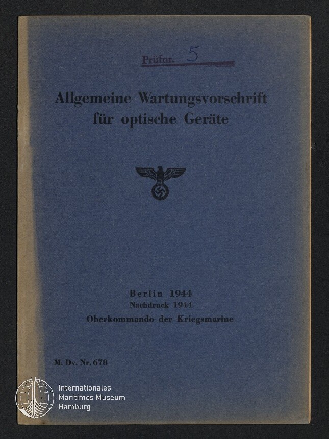 Blaue Buchumschlag eines deutschen Kriegsmarine‑Handbuchs von 1944 mit dem Titel Allgemeine Wartungsvorschrift für optische Geräte, Adler mit Hakenkreuz in der Mitte, violetter Stempel „Prüfr. 5“ oben und Museumswasserzeichen unten links.