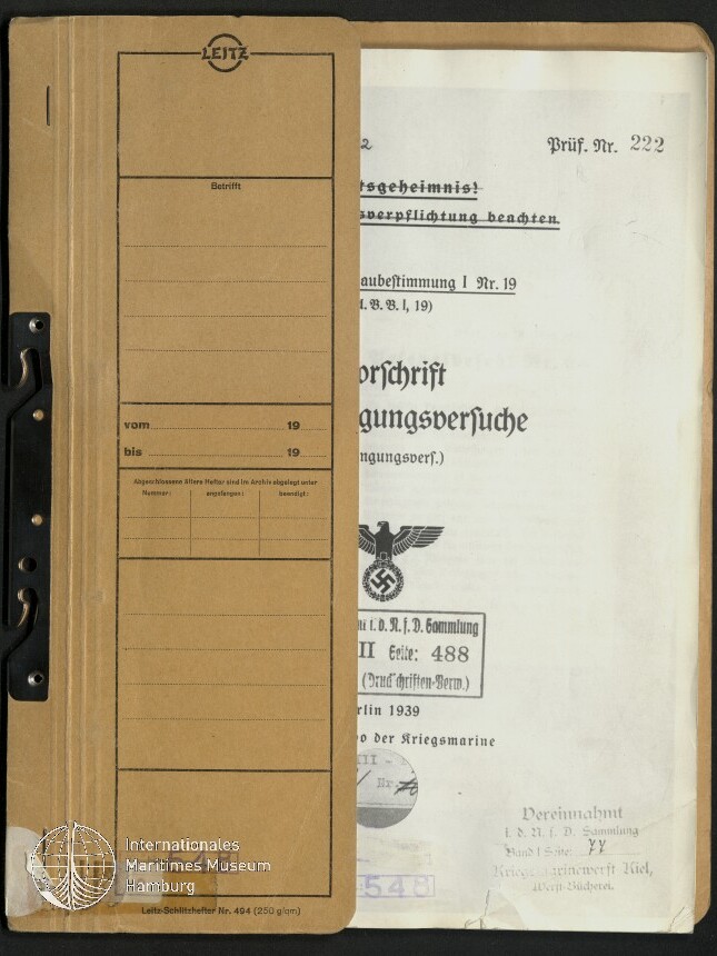 Geöffnetes braunes Leitz-Aktenheft mit Metallklammer links und vorgedrucktem Formular auf der Innenseite, rechts ein herausragendes deutschsprachiges Dokument mit Reichsadler und Hakenkreuz sowie mehreren Stempeln und Museumswasserzeichen.