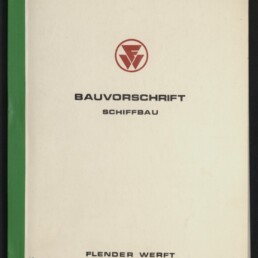 Deckblatt eines technischen Heftes mit grünem Buchrücken, mittig rotem Firmenlogo und Titel ‚BAUVORSCHRIFT SCHIFFBAU‘, handschriftlichem Vermerk ‚Stand: 7.1.1983‘ oben rechts sowie dem Firmennamen ‚FLENDER WERFT‘ unten auf weißem Hintergrund, links unten Stempel des Internationalen Maritimen Museums.