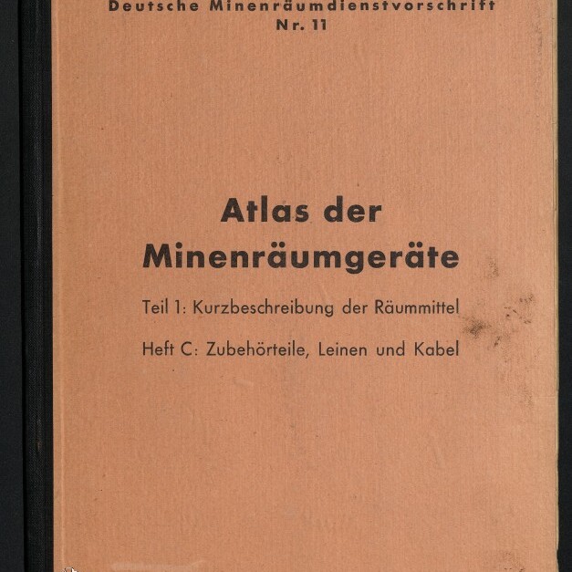 Orangefarbener Bucheinband mit schwarzem Rücken, gedrucktem Titel »Atlas der Minenräumgeräte – Teil 1: Kurzbeschreibung der Räummittel; Heft C: Zubehörteile, Leinen und Kabel«, darüber die Aufschrift »Deutsche Minenräumdienstvorschrift Nr. 11« und ein handschriftlicher Prüfvermerk.