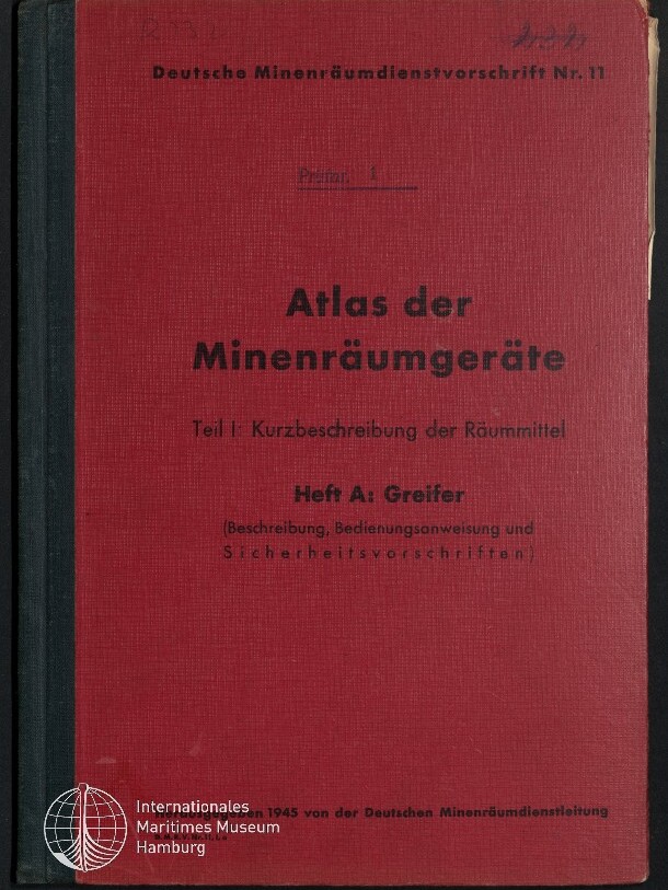 Rotes Leinenbuch mit schwarzem Rücken und schwarzer Aufschrift ‚Atlas der Minenräumgeräte – Teil I: Kurzbeschreibung der Räummittel, Heft A: Greifer‘; oben steht ‚Deutsche Minenräumdienstvorschrift Nr. 11‘ und unten ist das weiße Signet des Internationalen Maritimen Museums Hamburg zu sehen.