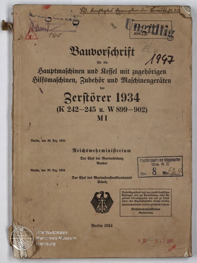 Vergilbtes Deckblatt eines technischen Handbuchs mit dem Titel ‚Bauvorschrift … Zerstörer 1934‘ in schwarzer Frakturschrift, versehen mit handschriftlichen Notizen (u. a. ‚1947‘), mehreren Stempeln (darunter ‚Ungültig‘), dem Reichsadler-Emblem unten, Eselsohren, einer Bindeschnur am linken Rand und dem Wasserzeichen des Internationalen Maritimen Museums Hamburg.