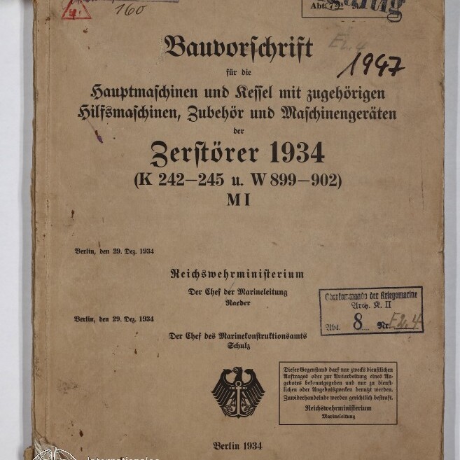 Vergilbtes Deckblatt eines technischen Handbuchs mit dem Titel ‚Bauvorschrift … Zerstörer 1934‘ in schwarzer Frakturschrift, versehen mit handschriftlichen Notizen (u. a. ‚1947‘), mehreren Stempeln (darunter ‚Ungültig‘), dem Reichsadler-Emblem unten, Eselsohren, einer Bindeschnur am linken Rand und dem Wasserzeichen des Internationalen Maritimen Museums Hamburg.