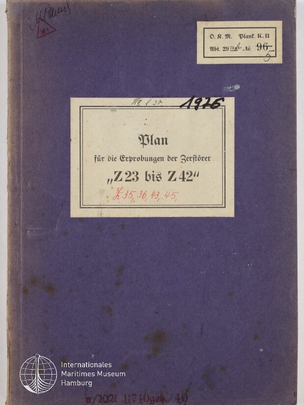 Lila Buchdeckel mit aufgeklebtetem weißem Etikett auf dem in Frakturschrift steht „Plan für die Erprobungen der Zerstörer ‚Z 23 bis Z 42‘“, dazu handschriftliche Nummern, ein kleiner Aufkleber oben rechts, Gebrauchsspuren und das Logo des Internationalen Maritimen Museums Hamburg unten links.