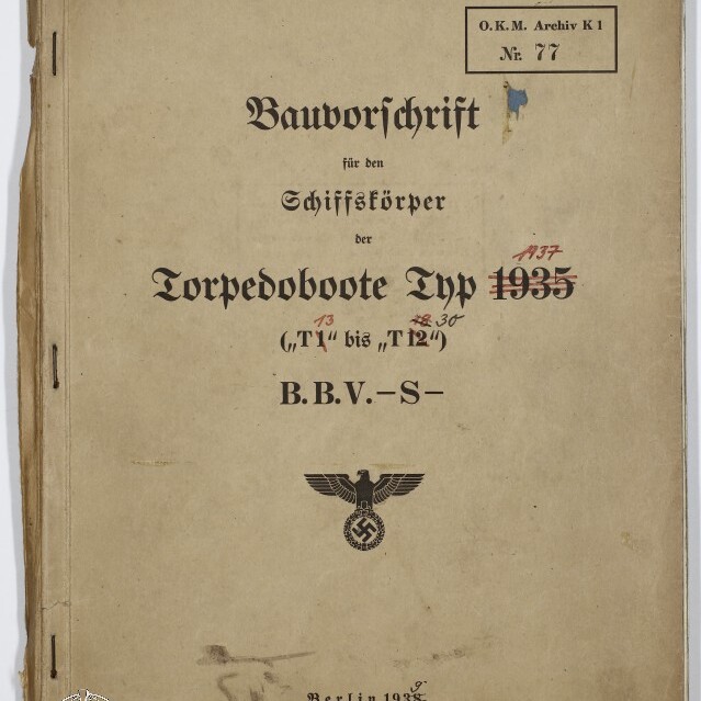 Vergilbtes Titelblatt eines Dienstvorschriftshefts aus Berlin 1938 mit der Überschrift 'Bauvorschrift' für 'Torpedoboote Typ 1935' in schwarzer Frakturschrift, handschriftlichen roten und blauen Nummern und Stempeln, links mit Heftung, einem Reichsadler mit Hakenkreuz und einem Museumswasserzeichen unten links.