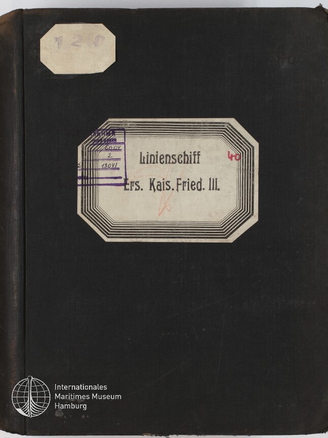 Schwarzer Buchdeckel mit zwei Etiketten: oben links ein abgegriffenes achteckiges Papieretikett mit der schwach gestempelten Nummer 120, zentral ein ornamentierter rechteckiger Aufkleber mit dem gedruckten Text „Linienschiff Ers. Kais. Fried. III.“ sowie violetten Stempel- und roten Handschriftspuren, unten links das Logo des Internationalen Maritimen Museums Hamburg.