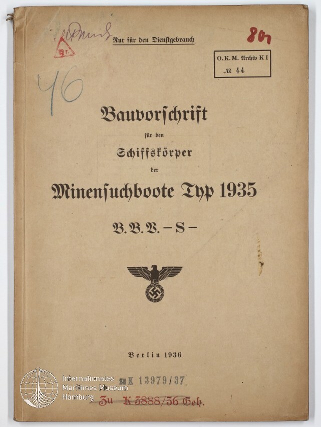 Gealtertes beige Buchcover mit der Titelaufschrift ‚Bauvorschrift für den Schiffskörper der Minensuchboote Typ 1935 B.B.V.-S-‘, gestempelt ‚Berlin 1936‘, einem nationalsozialistischen Reichsadler über Hakenkreuz, handschriftlichen Notizen oben und einem Museumsstempel unten links.