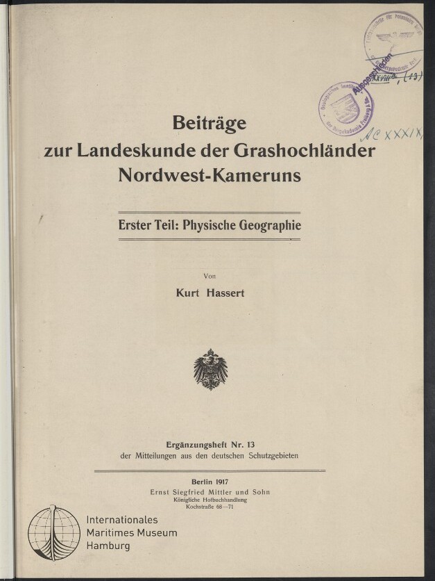 Titelblatt der Publikation Beiträge zur Landeskunde der Grashochländer Nordwest-Kameruns — Erster Teil: Physische Geographie von Kurt Hassert, mit mittigem Reichsadler-Emblem, mehreren Amtsstempeln oben rechts, Verlagsangabe Berlin 1917 und Museumssiegel des Internationalen Maritimen Museums Hamburg unten links.