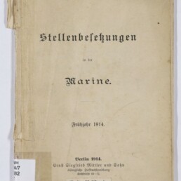 Deckblatt eines vergilbten Hefts mit dem Titel ‚Stellenbesetzungen in der Marine. Frühjahr 1914‘ in Frakturschrift, mit handschriftlicher Nummer oben, Klebestreifen und Knick am linken Rand sowie Museumsstempel unten links.