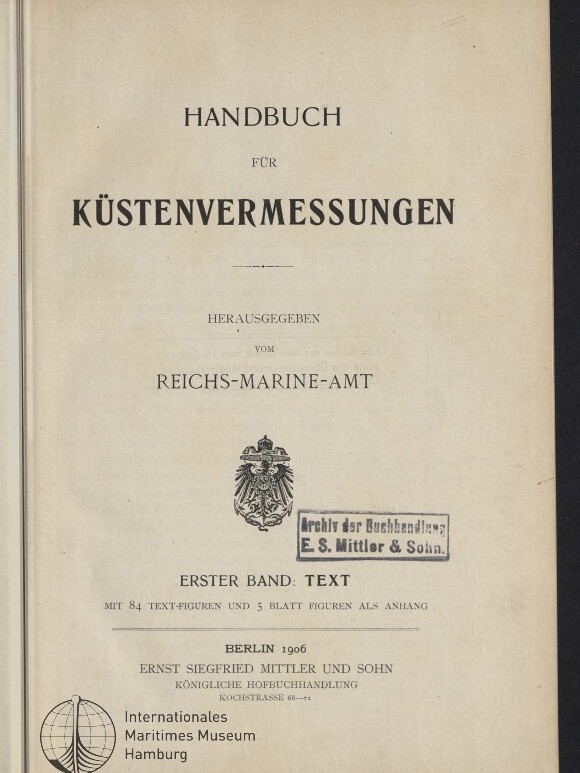 Titelblatt des Buches Handbuch für Küstenvermessungen, herausgegeben vom Reichs-Marine-Amt, mit Reichsadler-Wappen, rechteckigem Stempel Archiv der Buchhandlung E. S. Mittler & Sohn, Verlagsangaben Berlin 1906 und Logo des Internationalen Maritimen Museums Hamburg.