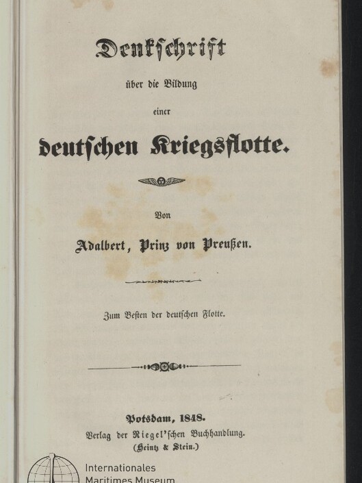 Titelblatt einer gealterten Broschüre von 1848 mit schwarzer Frakturschrift: „Denkschrift über die Bildung einer deutschen Kriegsflotte“ von Adalbert, Prinz von Preußen, mit Verlagsangaben, braunen Stockflecken und dem Logo des Internationalen Maritimen Museums Hamburg.