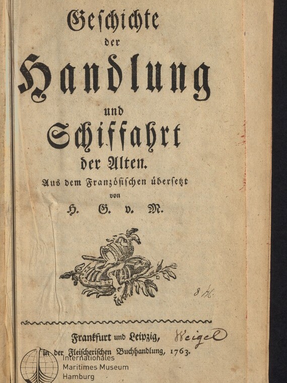 Titelblatt eines alten deutschen Buchs in schwarzer Frakturschrift mit dem Titel »Geschichte der Handlung und Schiffahrt der Alten«, darunter ein ornamentaler Holzschnitt mit Muschel und Blattwerk, handschriftliche Notizen sowie ein Stempel des Internationalen Maritimen Museums Hamburg; Verlagshinweis Frankfurt und Leipzig, 1763.