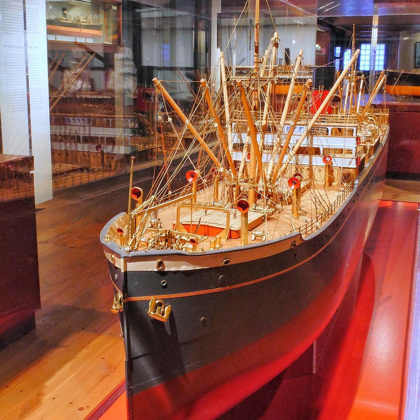 Detailaufnahme eines filigranen Schiffsmodells im Museum mit Masten, Takelage und roten Schornsteinen hinter Glas.