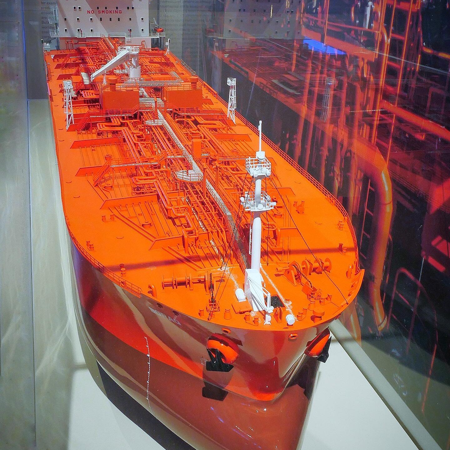Modell eines großen orangeroten Tankschiffs mit detailliertem Deck, Rohrleitungen und Aufbauten, beschriftet mit 