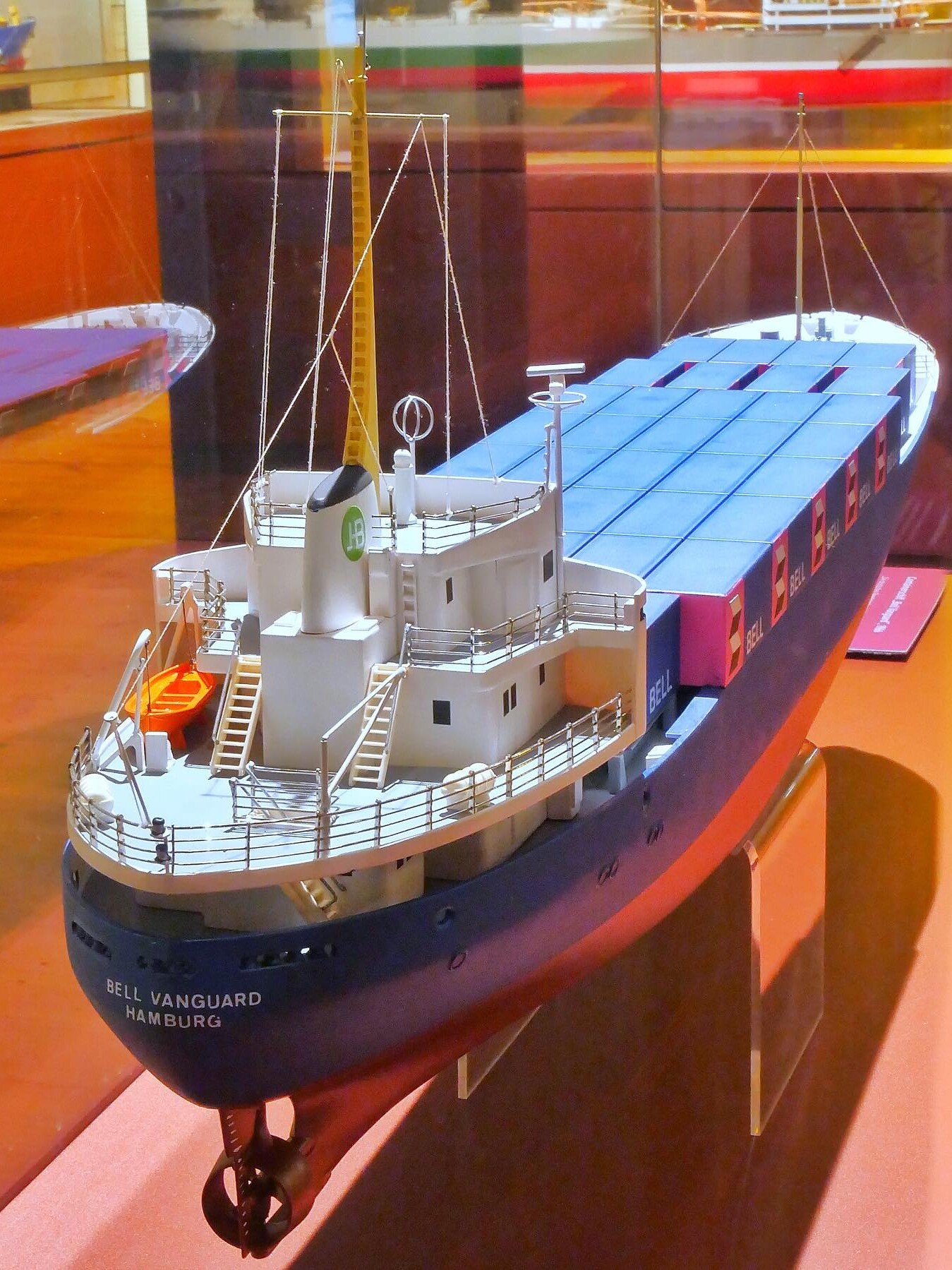 Modell eines Containerschiffs mit Brücke, Masten und blauen Containerkästen, Schriftzug „Bell Vanguard Hamburg“ am Bug.