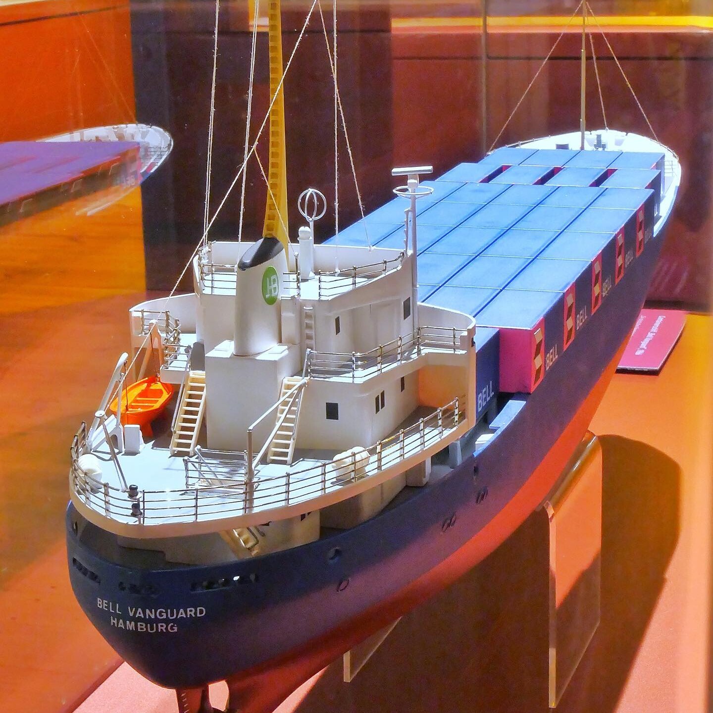 Modell eines Containerschiffs mit Brücke, Masten und blauen Containerkästen, Schriftzug „Bell Vanguard Hamburg“ am Bug.