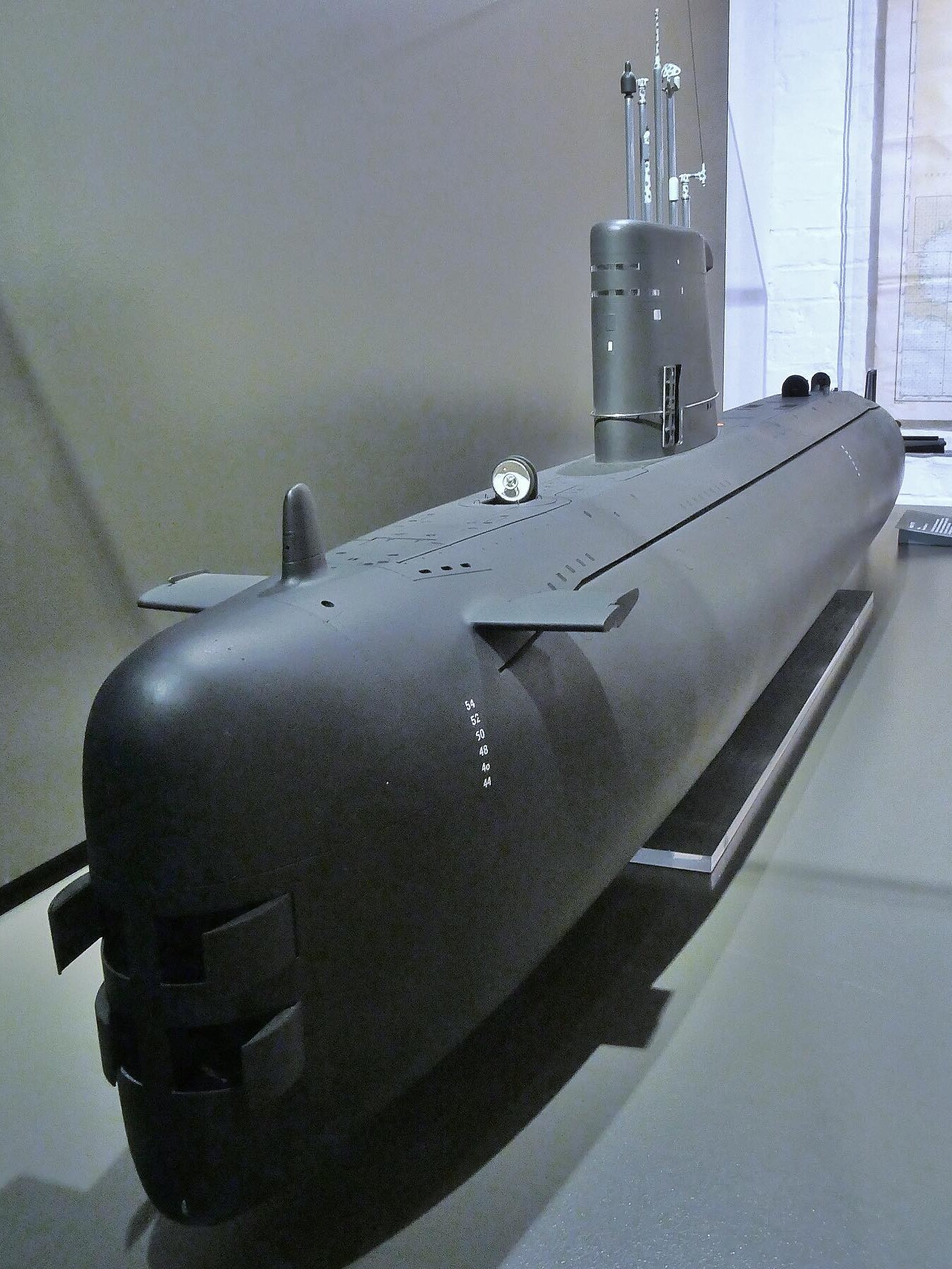 Modell eines modernen schwarzen U-Boot-Rumpfs mit Kommandoturm, Antennen und Steuerflossen auf Museumsdisplay.