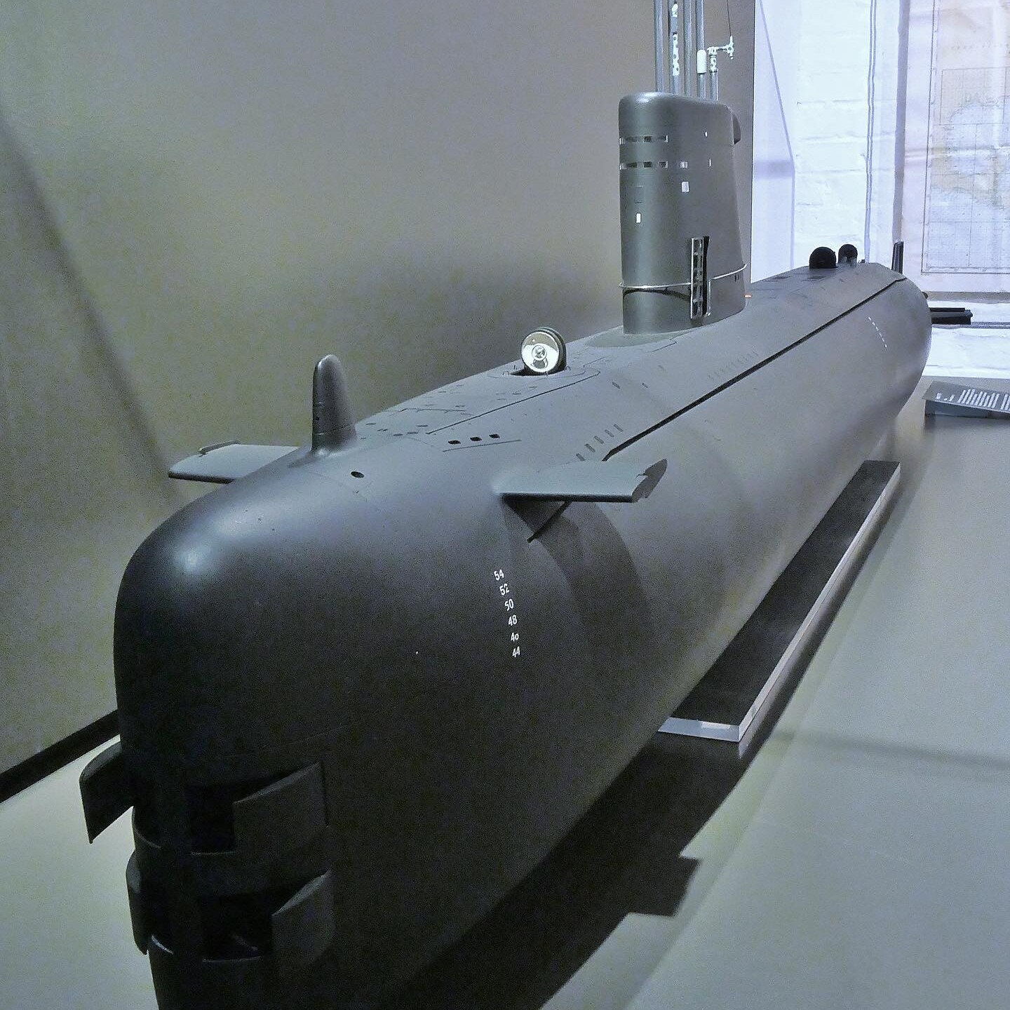 Modell eines modernen schwarzen U-Boot-Rumpfs mit Kommandoturm, Antennen und Steuerflossen auf Museumsdisplay.