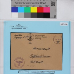 Brauner Dienstumschlag mit handschriftlicher Adresse, Reichsadlerstempel und Museumsetikett auf blauem Hintergrund, Farbkarte.