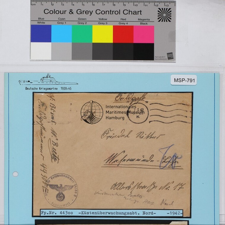 Dienstbriefumschlag der Deutschen Kriegsmarine (mit Reichsadler-Stempel) und handschriftlicher Adresse auf blauem Karton, Farbreferenz oben.