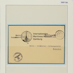 Historischer Umschlag mit Globuslogo und Poststempeln, montiert mit Aufschrift Internationales Maritimes Museum Hamburg.