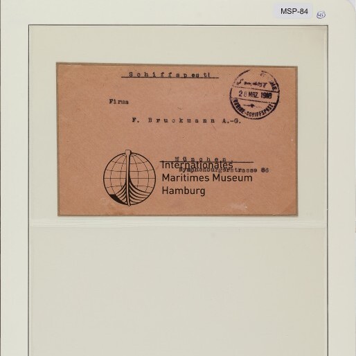 Brauner Umschlag mit Globuslogo, Poststempel und Aufdruck 'Internationales Maritimes Museum Hamburg' auf Archivblatt.