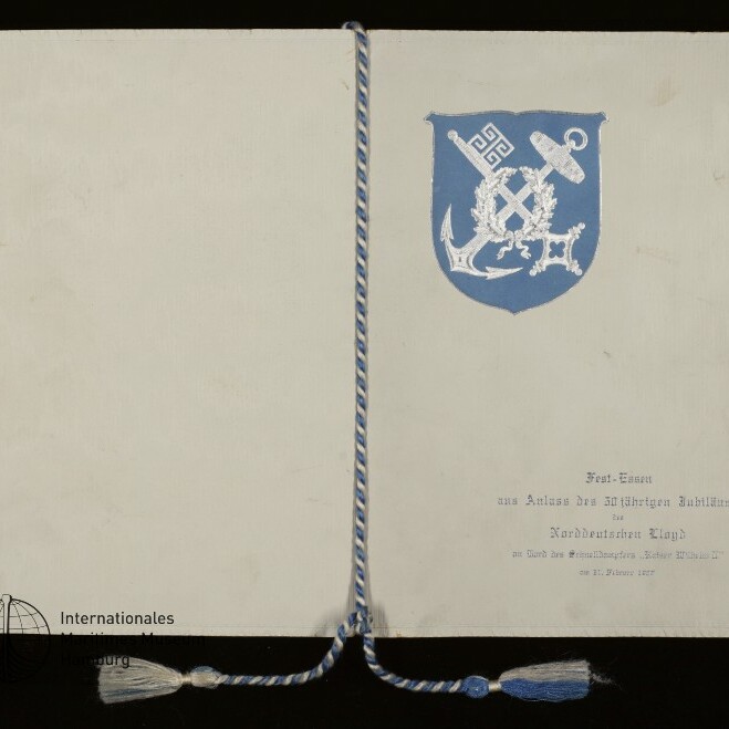Aufgeklapptes weißes Dokument mit einer blau-weiß geflochtenen Kordel und blauem Wappen mit Anker rechts.