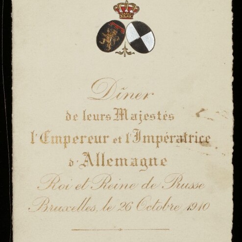 Elegante Einladungskarte mit gekröntem Wappen, schwarz-weißem Schild, goldener französischer Schrift 
